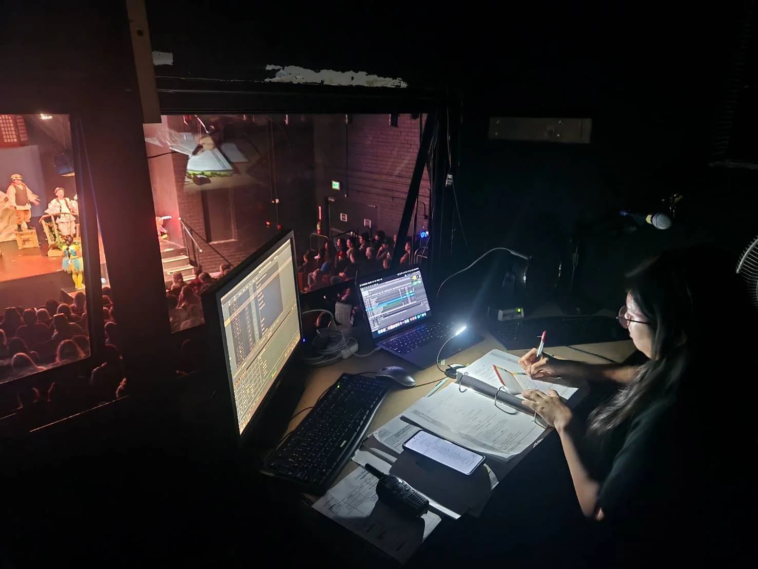 A team member working in a theatre control booth