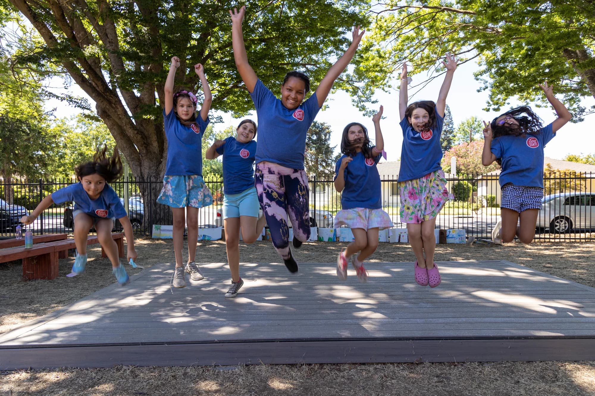 Summer campers jumping together outdoors