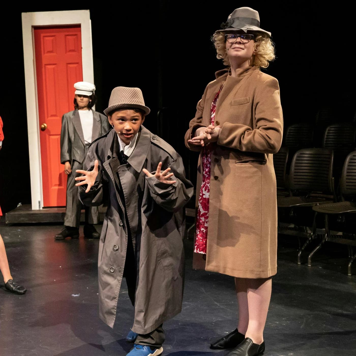 A young actor in a cap performing a character on the NorCal Arts stage