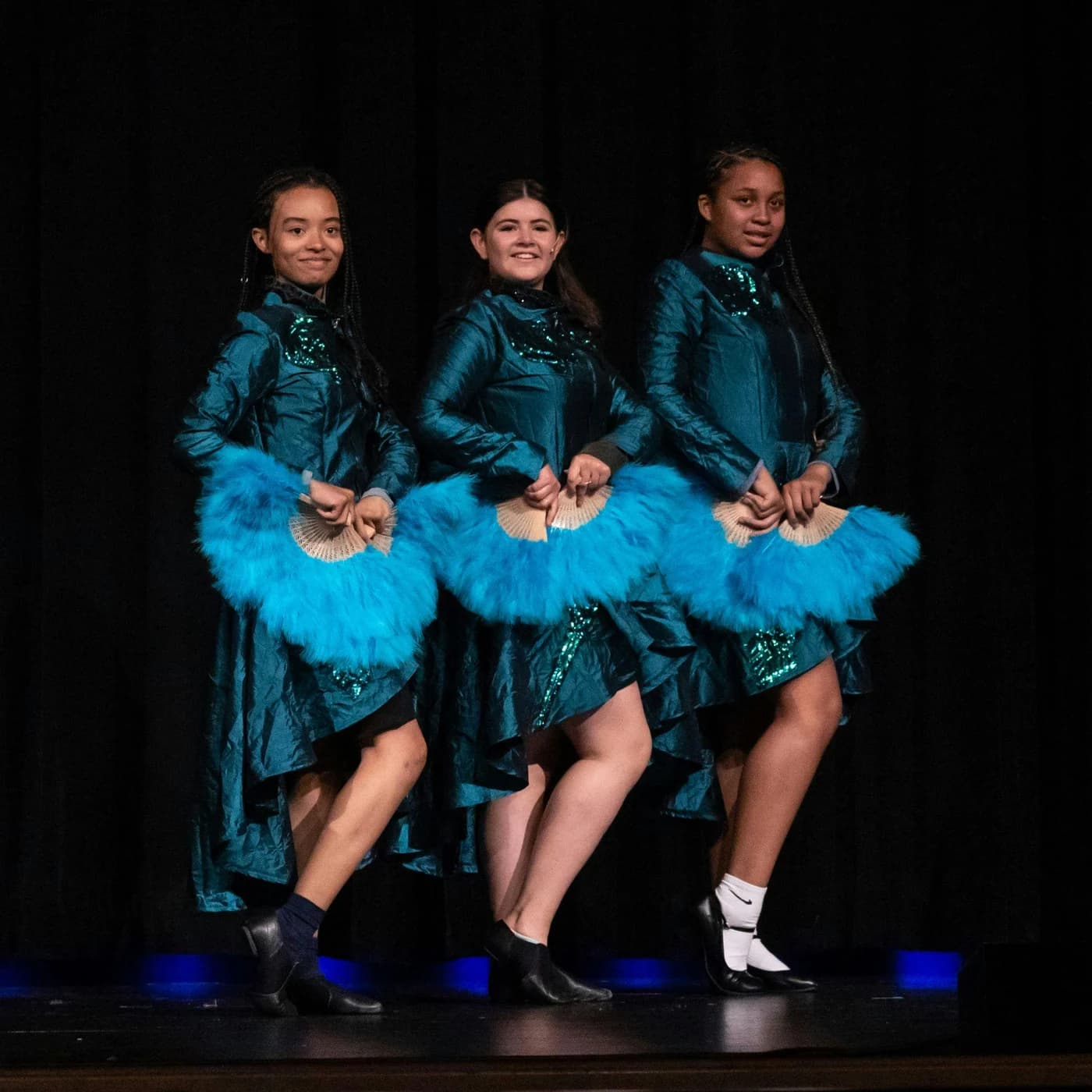 Young performers wearing coordinated blue theatrical costumes